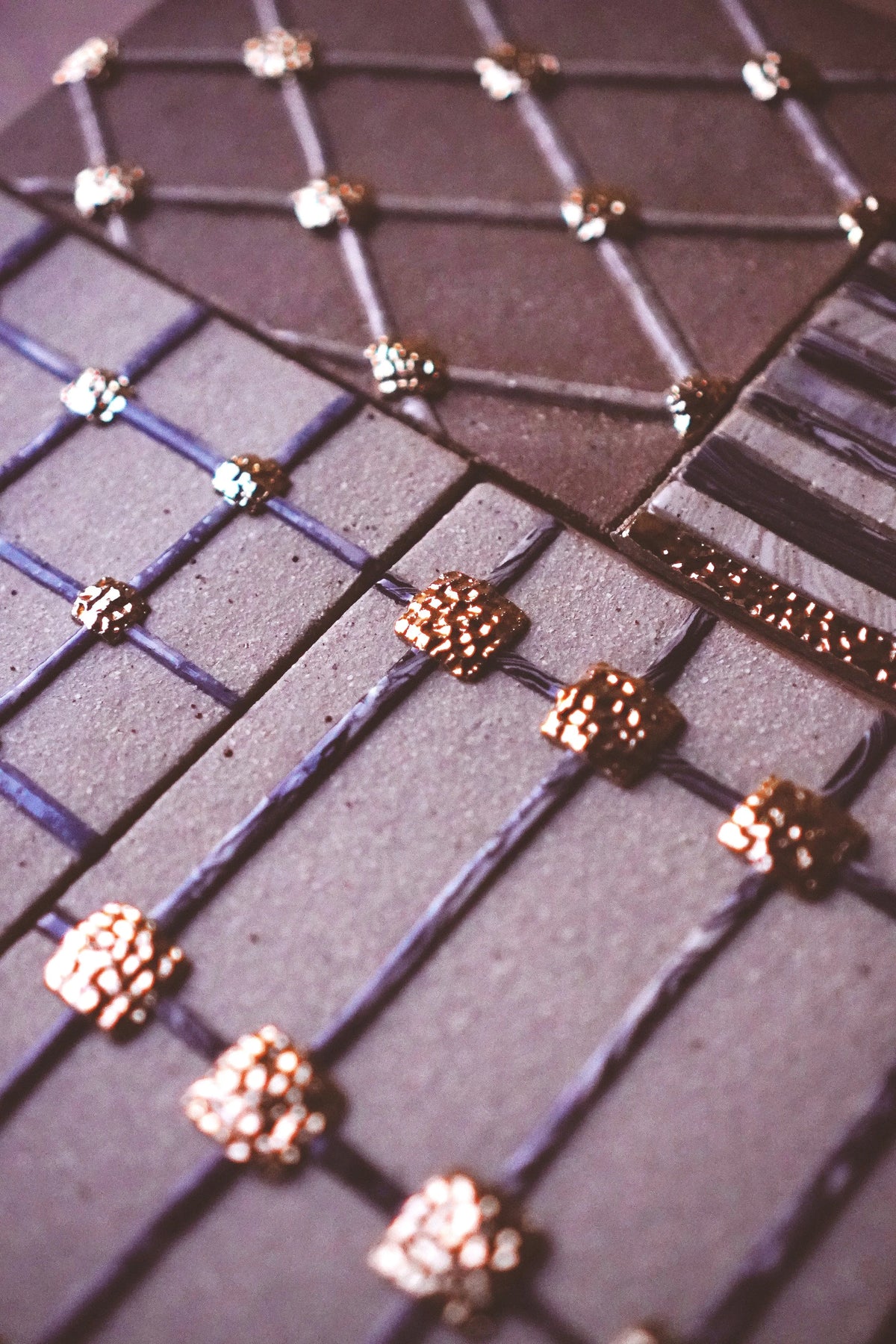 Gold lustre on a gridded surface, in Tantri Mustika’s studio