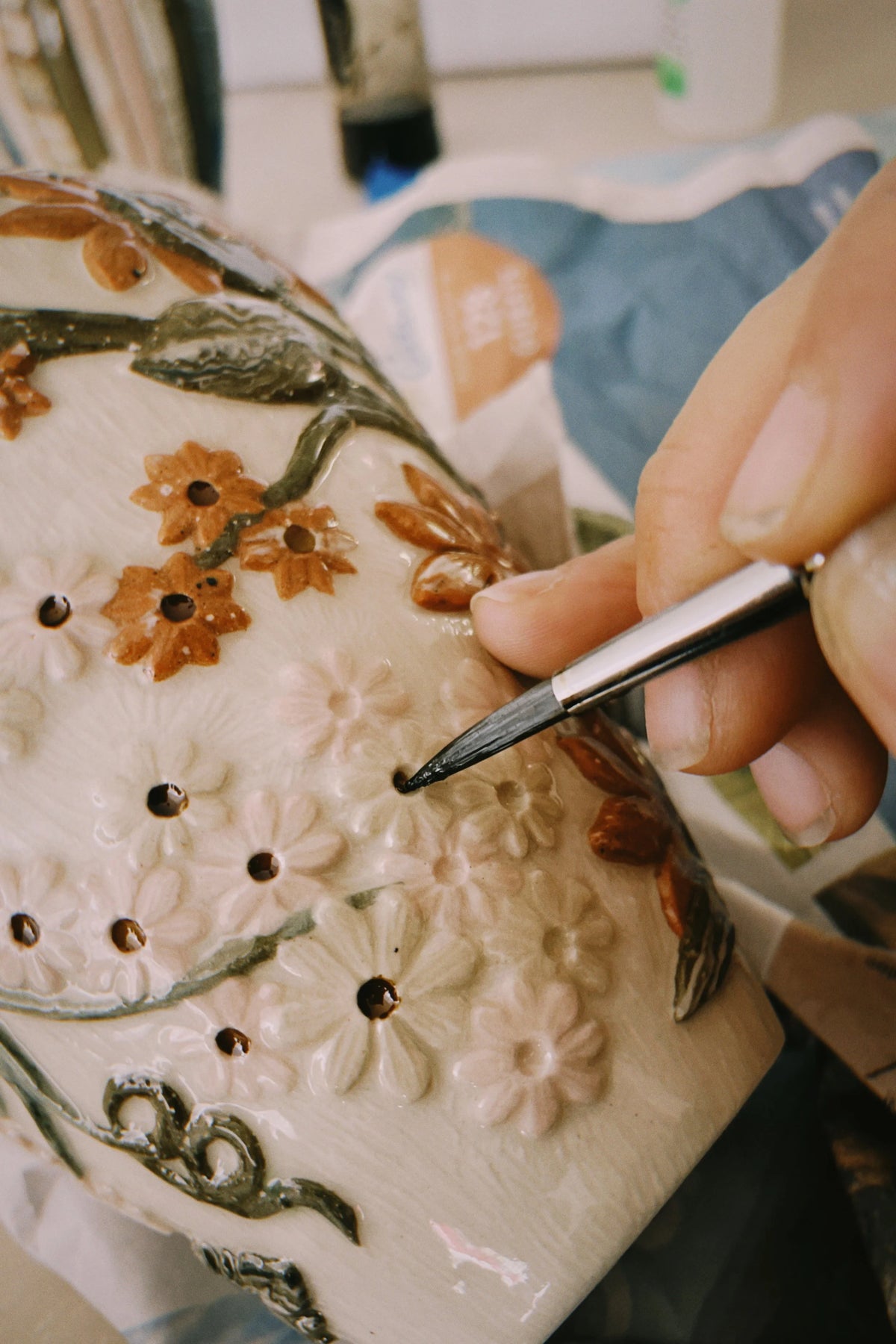Hand-painting detail onto carved flowers, in Tantri Mustika’s studio