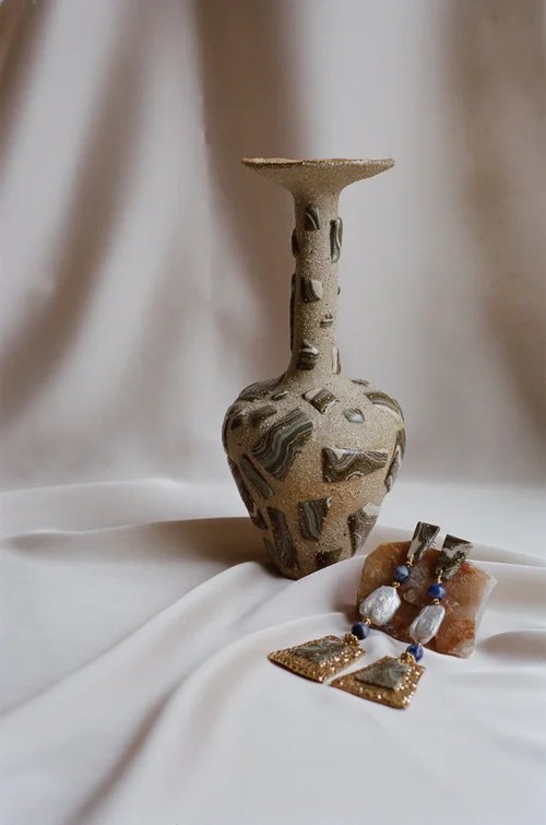 Stoneware vessel inlaid with marbled clay, beside ceramic earrings with gold lustre and beads, by Tantri Mustika, Adornment 2022