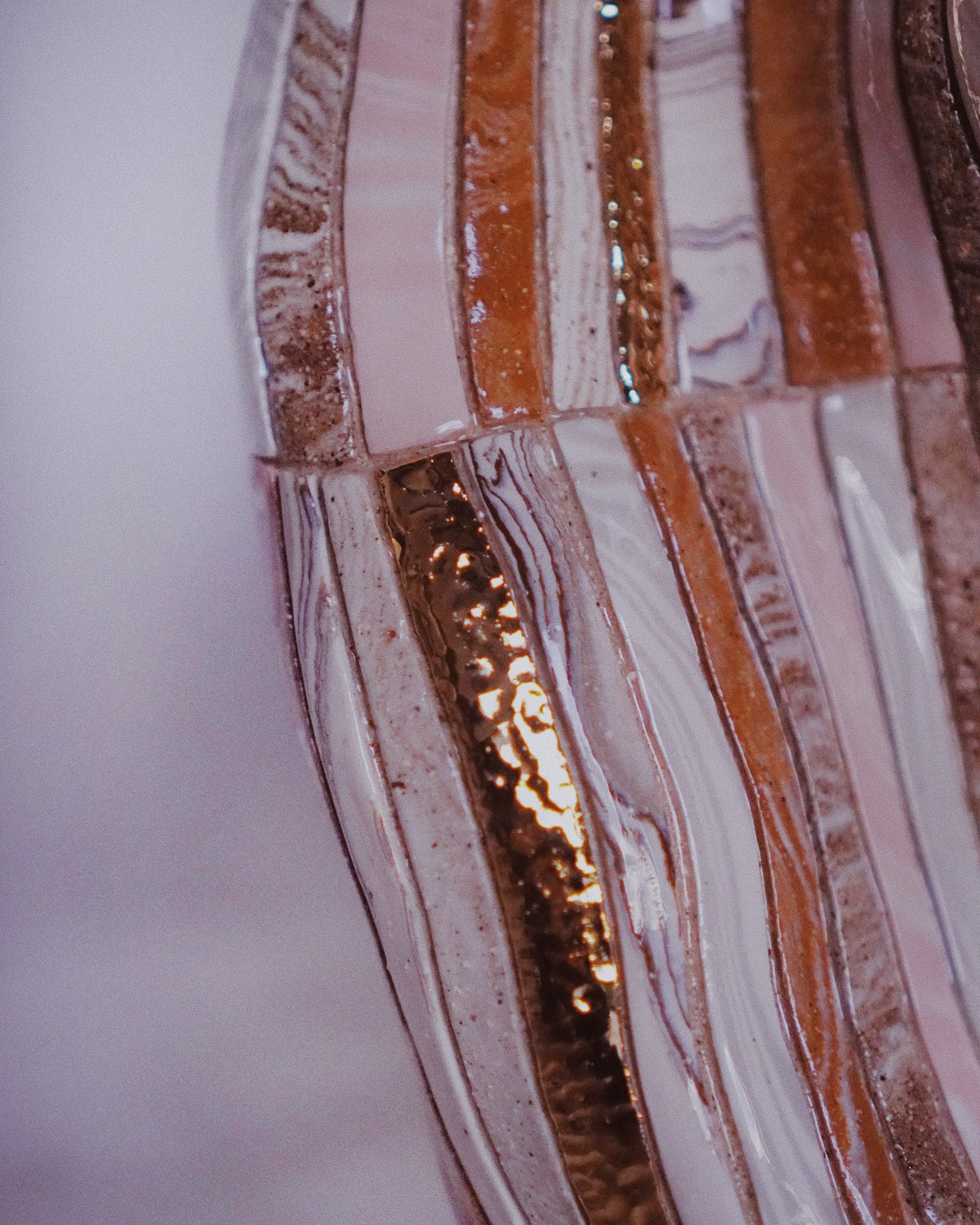 Detail of a Marmoreal vessel by Tantri Mustika: strips of marbled clay in blush and copper lustre