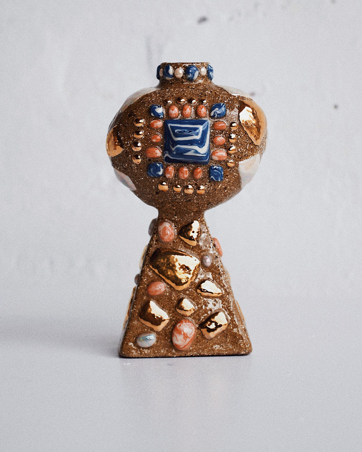 Vessel by Tantri Mustika set with a blue tile, coral dots and gold lustre fragments on a tapered stand, The Curiosities 2019