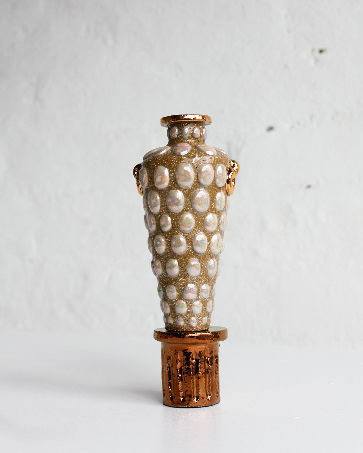 Vessel by Tantri Mustika covered in rows of white dots, on a lustred stand, The Curiosities 2019