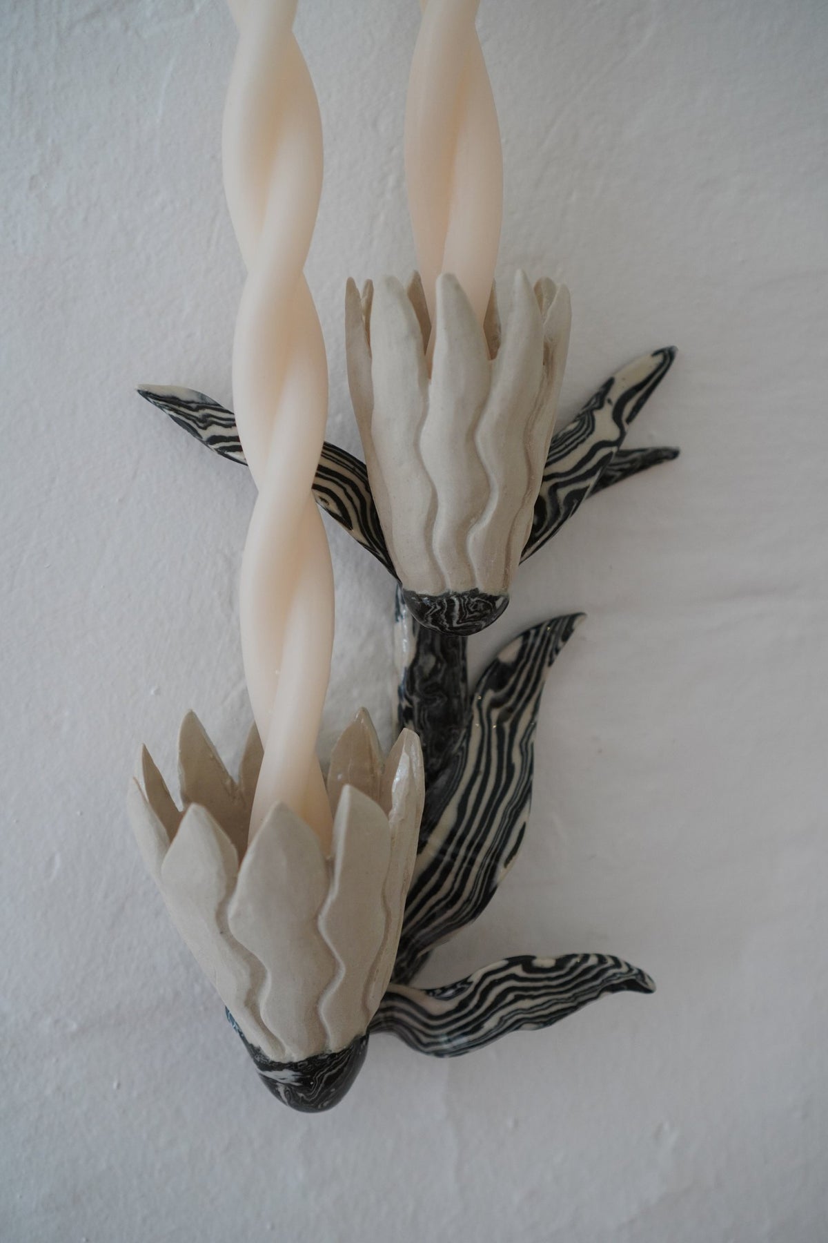Detail of an Unfurled candle sconce by Tantri Mustika: a stoneware bud with marbled leaves, Flame 2024