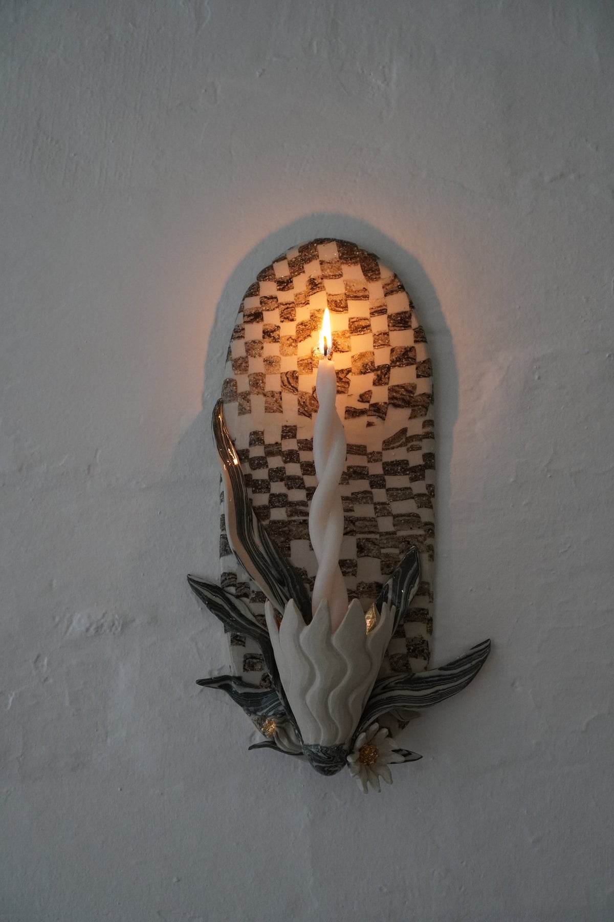 Checkered candle sconce by Tantri Mustika, lit, Flame 2024