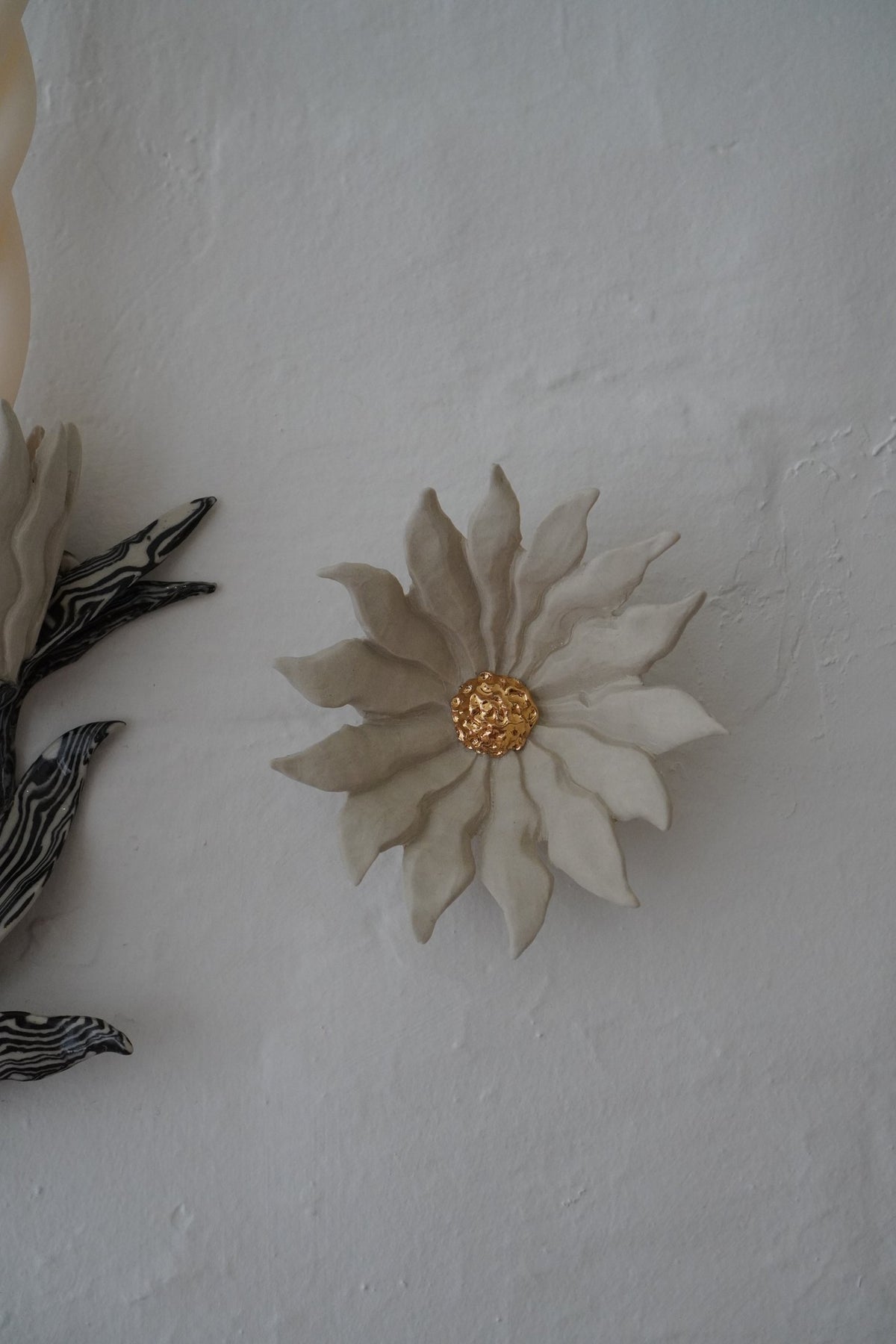 Open stoneware flower with a gold lustre centre, from Unfurled by Tantri Mustika, Flame 2024