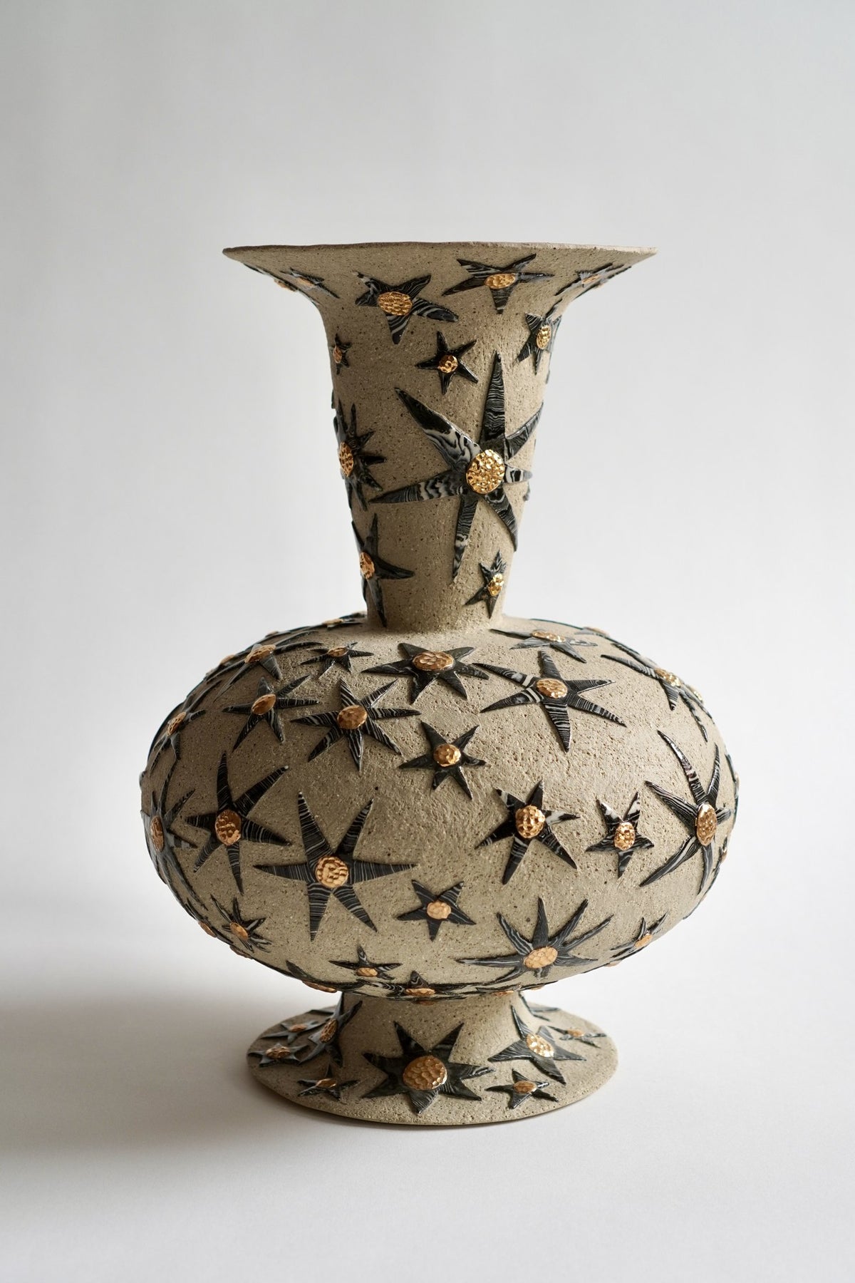 “It’s already written in the stars” #1 by Tantri Mustika: a stoneware vessel covered in black and white stars with gold lustre centres, 2024