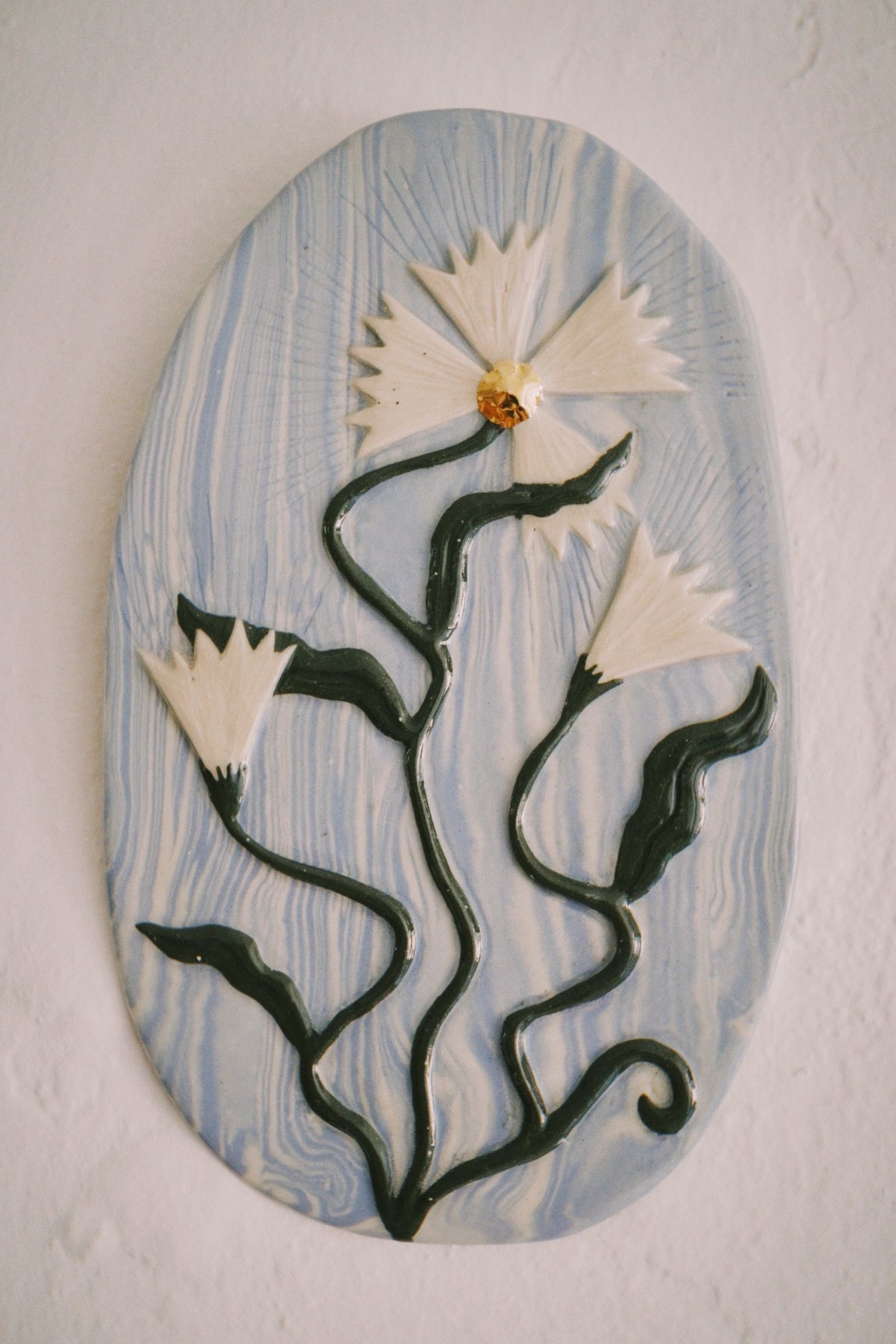 Ukiran wall plaque, blue marble with wildflowers, by Tantri Mustika